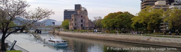 A placidly moving site seeing boat provides a juxtaposition to the Atomic Dome, Hiroshima environ, 2026-04-11, P. Potter.